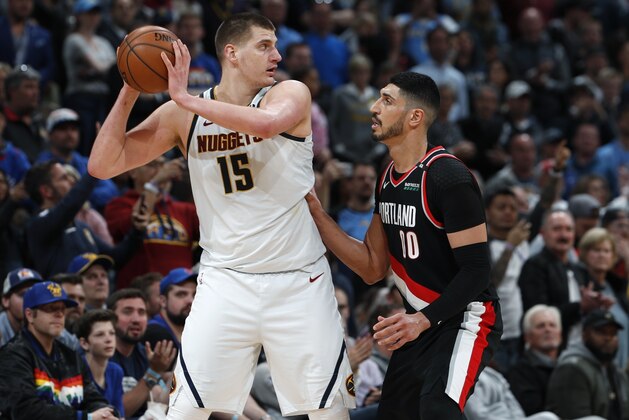 Denver Nuggets center Nikola Jokic, left, looks to pass the ball as Portland Trail Blazers center Enes Kanter defends in the second half of Game 1 of an NBA basketball second-round playoff series Monday, April 29, 2019, in Denver. The Nuggets won 121-113. (AP Photo/David Zalubowski)