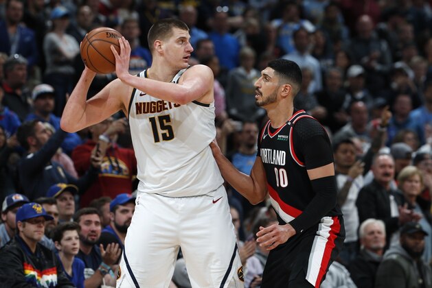 Denver Nuggets center Nikola Jokic, left, looks to pass the ball as Portland Trail Blazers center Enes Kanter defends in the second half of Game 1 of an NBA basketball second-round playoff series Monday, April 29, 2019, in Denver. The Nuggets won 121-113. (AP Photo/David Zalubowski)