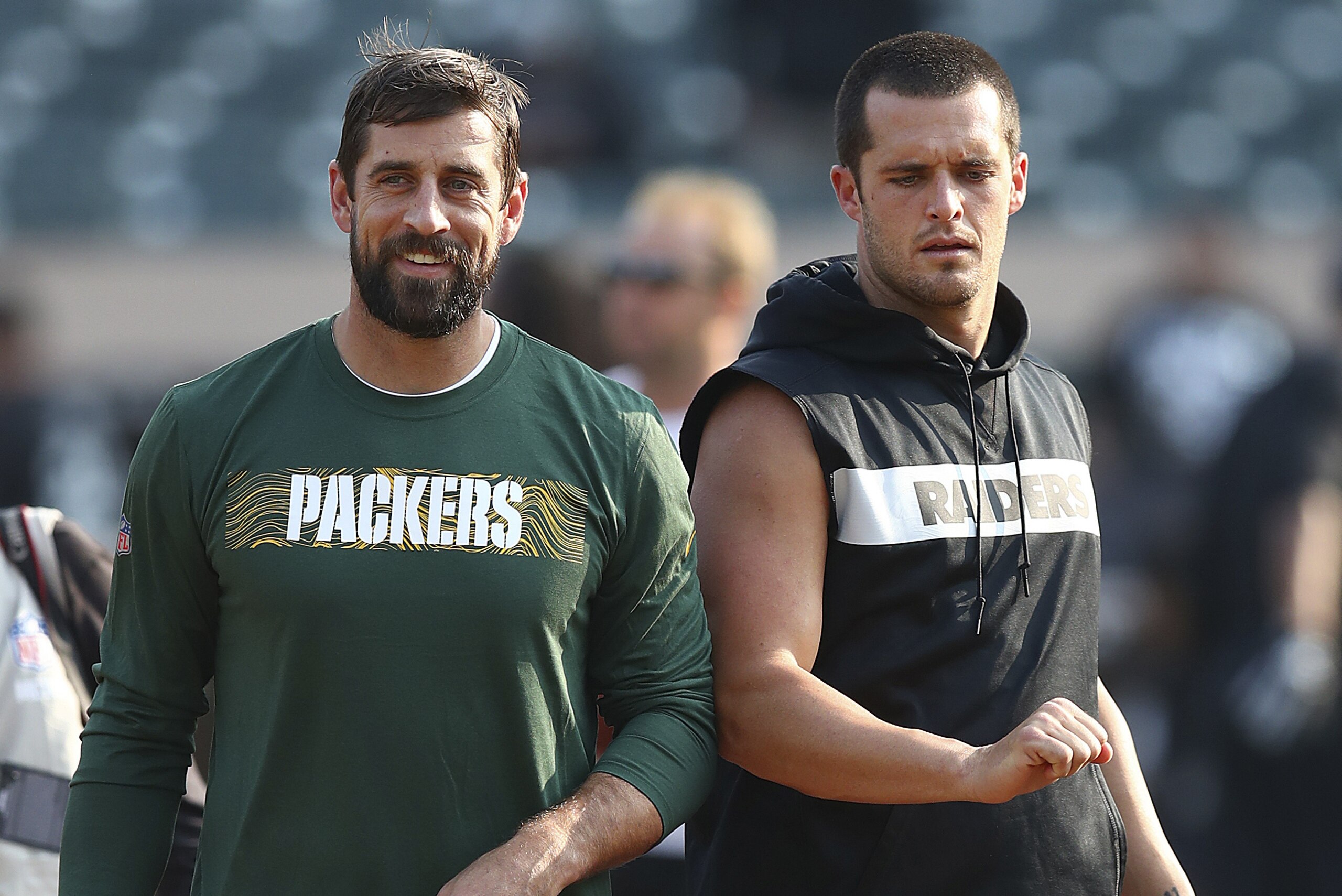 Green Bay Packers quarterback Aaron Rodgers, left, talks with Oakland Raiders quarterback Derek Carr before an NFL preseason football game in Oakland, Calif., Friday, Aug. 24, 2018. (AP Photo/Ben Margot)