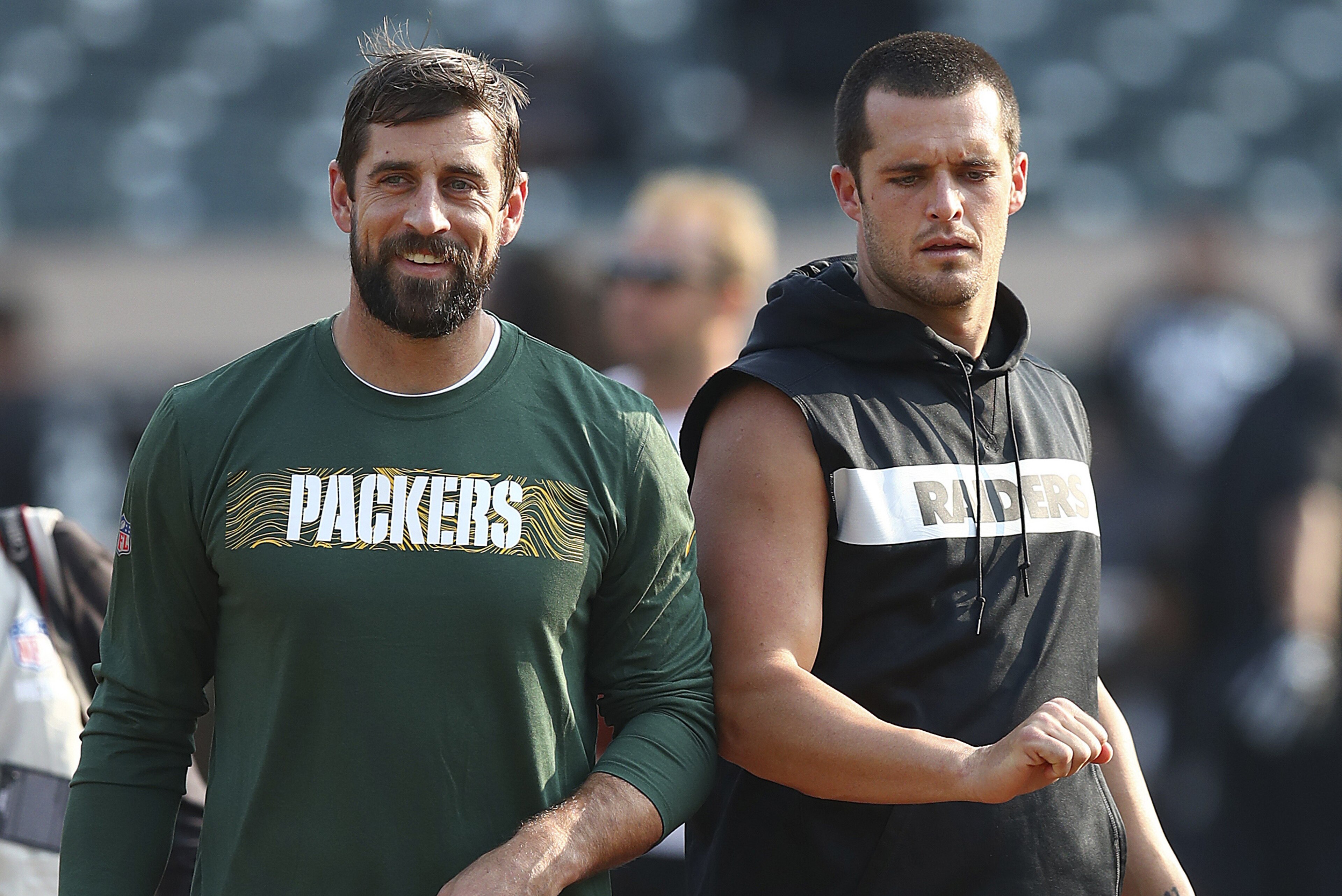 Green Bay Packers quarterback Aaron Rodgers, left, talks with Oakland Raiders quarterback Derek Carr before an NFL preseason football game in Oakland, Calif., Friday, Aug. 24, 2018. (AP Photo/Ben Margot)