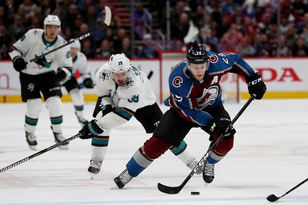 DENVER, COLORADO - MAY 02: Nathan MacKinnon #29 of the Colorado Avalanche advances the puck against Logan Couture #39 of  the San Jose Sharks in the second period during Game Four of the Western Conference Second Round during the 2019 NHL Stanley Cup Playoffs at the Pepsi Center on May 2, 2019 in Denver, Colorado.  (Photo by Matthew Stockman/Getty Images)