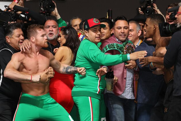 LAS VEGAS, NEVADA - MAY 03:  Canelo Alvarez and Daniel Jacobs get into a shoving match as Golden Boy Promotter Oscar De La Hoya intervenes during their official weigh in at T-Mobile Arena on May 3, 2019 in Las Vegas, Nevada.  Alvarez and Jacobs will fight to unify the WBC WBA and IBF Titles on May 04, 2019 at T-Mobile Arena. (Photo by Al Bello/Getty Images)