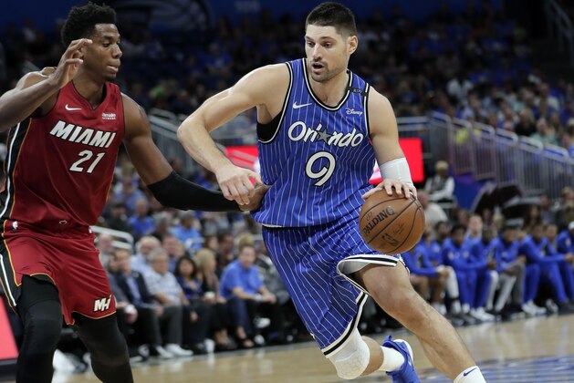 Orlando Magic's Nikola Vucevic (9) drives around Miami Heat's Hassan Whiteside (21) during the second half of an NBA basketball game, Wednesday, Oct. 17, 2018, in Orlando, Fla. (AP Photo/John Raoux)