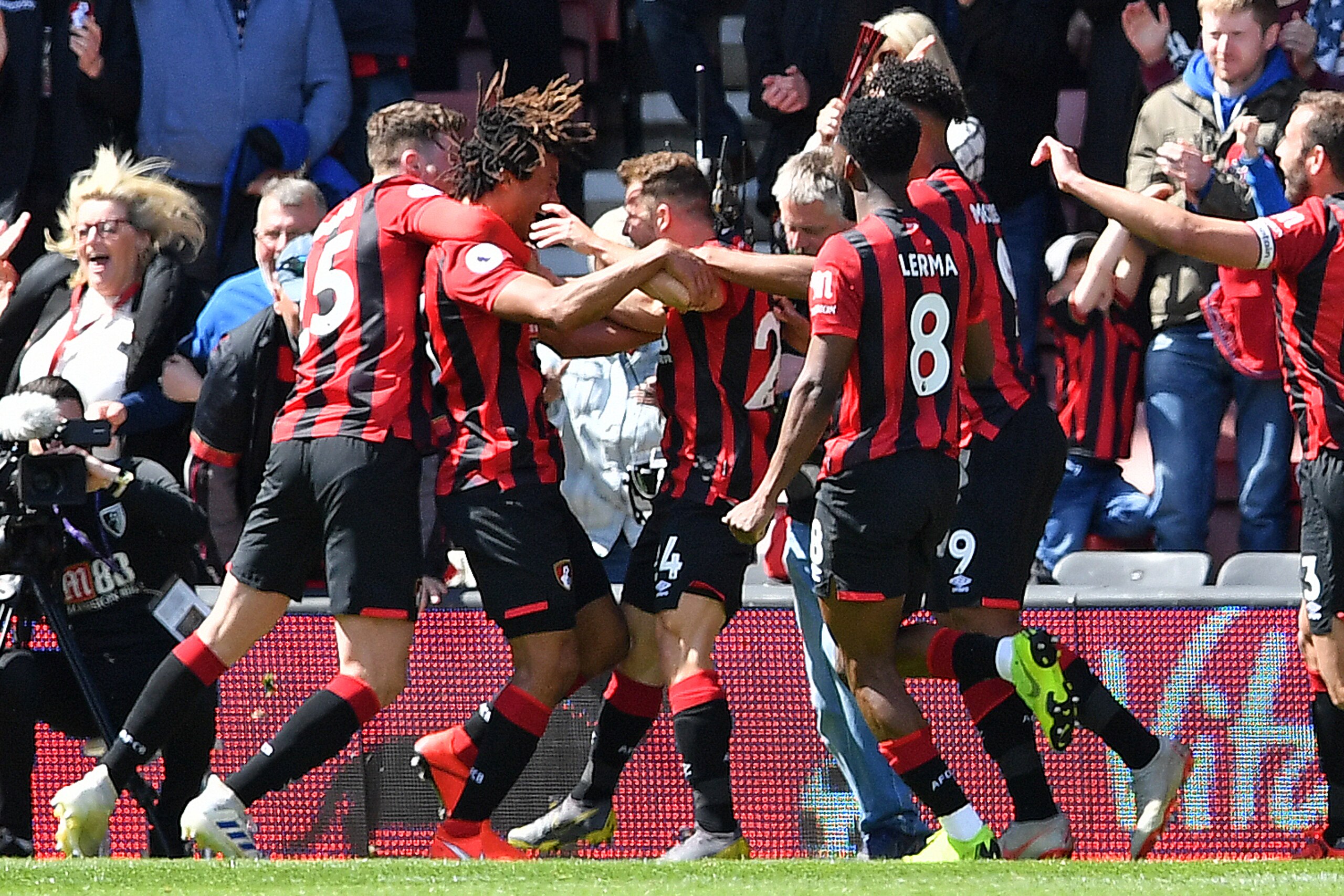 Bournemouth's Dutch defender Nathan Ake (2L) is mobbed by teammates after scoring the opening goal in the closing minutes of the English Premier League football match between Bournemouth and Tottenham Hotspur at the Vitality Stadium in Bournemouth, southern England on May 4, 2019. (Photo by Ben STANSALL / AFP) / RESTRICTED TO EDITORIAL USE. No use with unauthorized audio, video, data, fixture lists, club/league logos or 'live' services. Online in-match use limited to 120 images. An additional 40 images may be used in extra time. No video emulation. Social media in-match use limited to 120 images. An additional 40 images may be used in extra time. No use in betting publications, games or single club/league/player publications. /         (Photo credit should read BEN STANSALL/AFP/Getty Images)