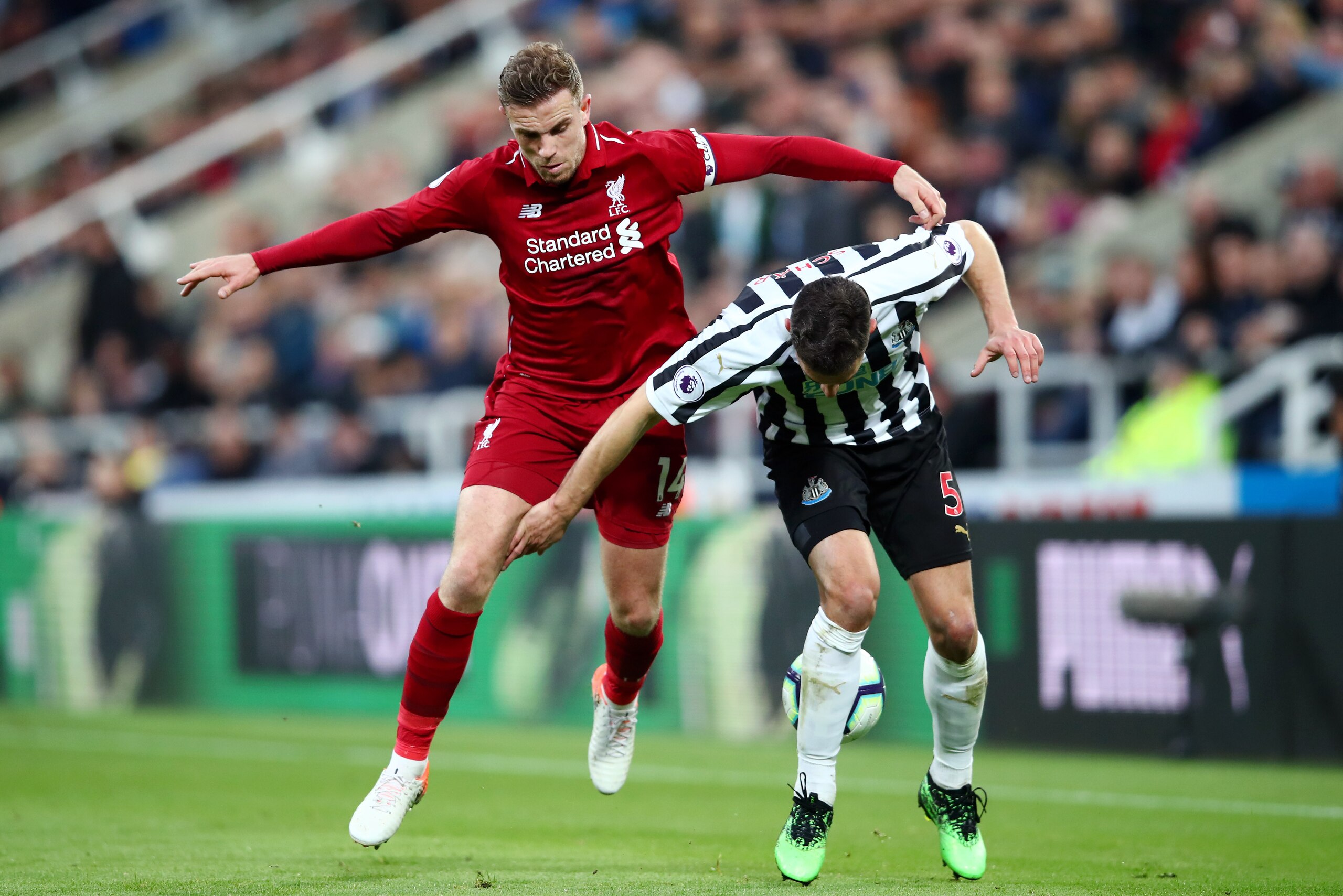 NEWCASTLE UPON TYNE, ENGLAND - MAY 04: Fabian Schar of Newcastle United is challenged by Jordan Henderson of Liverpool during the Premier League match between Newcastle United and Liverpool FC at St. James Park on May 04, 2019 in Newcastle upon Tyne, United Kingdom. (Photo by Clive Brunskill/Getty Images)