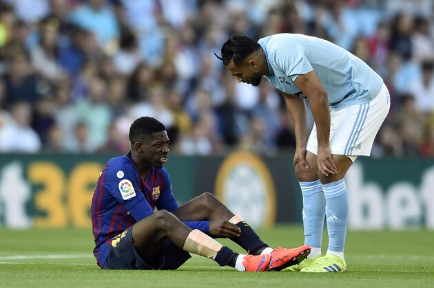 Celta Vigo's Moroccan midfielder Sofiane Boufal (R) checks on Barcelona's French forward Ousmane Dembele after resulting injured during the Spanish league football match between RC Celta de Vigo and FC Barcelona at the Balaidos stadium in Vigo on May 4, 2019. (Photo by Miguel RIOPA / AFP) / The erroneous byline appearing in the metadata of this photo by MIGUEL RIOPA has been modified in AFP systems in the following manner: [Miguel Riopa] instead of [Oscar Pozo]. Please immediately remove the erroneous mention[s] from all your online services and delete it (them) from your servers. If you have been authorized by AFP to distribute it (them) to third parties, please ensure that the same actions are carried out by them. Failure to promptly comply with these instructions will entail liability on your part for any continued or post notification usage. Therefore we thank you very much for all your attention and prompt action. We are sorry for the inconvenience this notification may cause and remain at your disposal 
