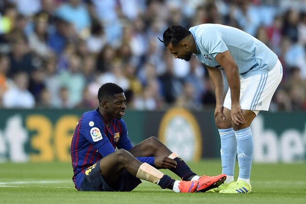 Celta Vigo's Moroccan midfielder Sofiane Boufal (R) checks on Barcelona's French forward Ousmane Dembele after resulting injured during the Spanish league football match between RC Celta de Vigo and FC Barcelona at the Balaidos stadium in Vigo on May 4, 2019. (Photo by Miguel RIOPA / AFP) / The erroneous byline appearing in the metadata of this photo by MIGUEL RIOPA has been modified in AFP systems in the following manner: [Miguel Riopa] instead of [Oscar Pozo]. Please immediately remove the erroneous mention[s] from all your online services and delete it (them) from your servers. If you have been authorized by AFP to distribute it (them) to third parties, please ensure that the same actions are carried out by them. Failure to promptly comply with these instructions will entail liability on your part for any continued or post notification usage. Therefore we thank you very much for all your attention and prompt action. We are sorry for the inconvenience this notification may cause and remain at your disposal 