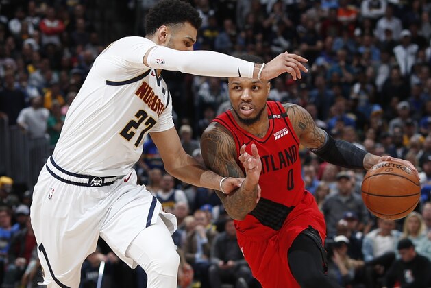 Portland Trail Blazers guard Damian Lillard, right, drives as Denver Nuggets guard Jamal Murray defends during the second half of Game 2 of an NBA basketball second-round playoff series Wednesday, May 1, 2019, in Denver. Portland won 97-90. (AP Photo/David Zalubowski)