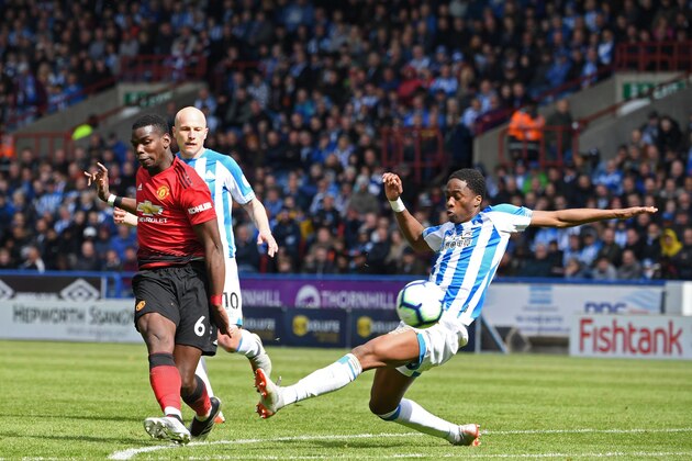 Manchester United's French midfielder Paul Pogba (L) has an unsuccessful shot as Huddersfield Town's Swiss-born Dutch defender Terence Kongolo (R) tries to block during the English Premier League football match between Huddersfield Town and Manchester United at the John Smith's stadium in Huddersfield, northern England on May 5, 2019. (Photo by Paul ELLIS / AFP) / RESTRICTED TO EDITORIAL USE. No use with unauthorized audio, video, data, fixture lists, club/league logos or 'live' services. Online in-match use limited to 120 images. An additional 40 images may be used in extra time. No video emulation. Social media in-match use limited to 120 images. An additional 40 images may be used in extra time. No use in betting publications, games or single club/league/player publications. /         (Photo credit should read PAUL ELLIS/AFP/Getty Images)