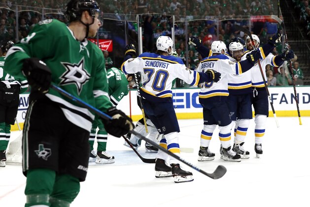 CORRECTS PLAYER AT LEFT TO DALLAS STARS' ESA LINDELL, OF FINLAND, AND NOT JOHN KLINGBERG, OF SWEDEN AS ORIGINALLY SENT -  - St. Louis Blues' David Perron, second from right, is congratulated by teammates after scoring as Dallas Stars' Esa Lindell, of Finland, left, watches during the second period in Game 6 of an NHL second-round hockey playoff series, Sunday, May 5, 2019, in Dallas. (AP Photo/Tony Gutierrez)