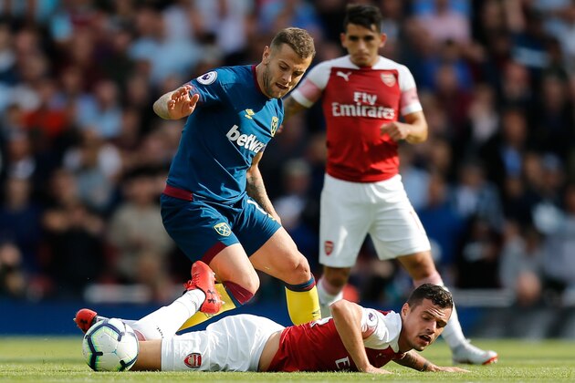 West Ham United's English midfielder Jack Wilshere (top) tangles with Arsenal's Swiss midfielder Granit Xhaka (bottom) during the English Premier League football match between Arsenal and West Ham United at the Emirates Stadium in London on August 25, 2018. (Photo by Ian KINGTON / AFP) / RESTRICTED TO EDITORIAL USE. No use with unauthorized audio, video, data, fixture lists, club/league logos or 'live' services. Online in-match use limited to 120 images. An additional 40 images may be used in extra time. No video emulation. Social media in-match use limited to 120 images. An additional 40 images may be used in extra time. No use in betting publications, games or single club/league/player publications. /         (Photo credit should read IAN KINGTON/AFP/Getty Images)