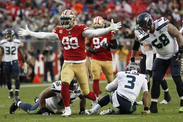 San Francisco 49ers defensive end DeForest Buckner (99) stands over Seattle Seahawks offensive guard Jordan Simmons (66) and quarterback Russell Wilson (3) after sacking Wilson during an NFL football game in Santa Clara, Calif., Sunday, Dec. 16, 2018. (AP Photo/Tony Avelar)