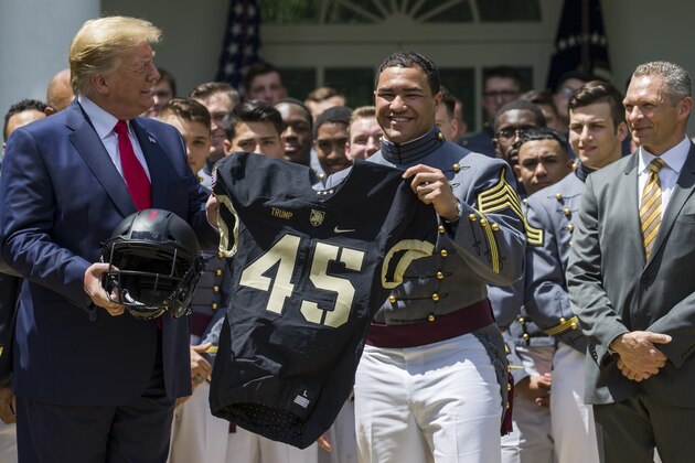 President Donald Trump accepts a jersey from Army running back Darnell Woolfolke Army during the presentation of the Commander-in-Chief's Trophy to the U.S. Military Academy at West Point football team in the Rose Garden of the White House, Monday, May 6, 2019, in Washington. (AP Photo/Alex Brandon)
