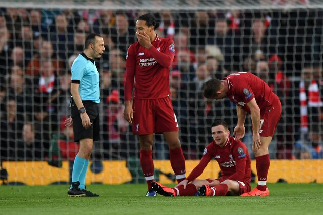 LIVERPOOL, ENGLAND - MAY 07:  An injured Andy Robertson of Liverpool is checked on by team mates Virgil van Dijk and James Milner during the UEFA Champions League Semi Final second leg match between Liverpool and Barcelona at Anfield on May 07, 2019 in Liverpool, England. (Photo by Shaun Botterill/Getty Images)