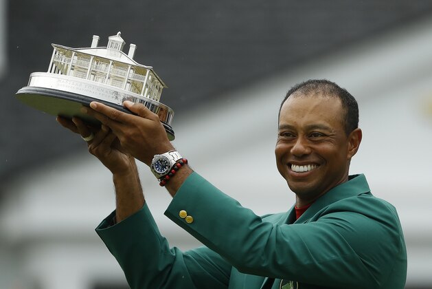 Tiger Woods wears his green jacket holding the winning trophy after the final round for the Masters golf tournament Sunday, April 14, 2019, in Augusta, Ga. (AP Photo/Matt Slocum)