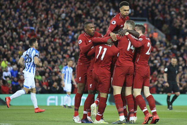 Liverpool teammates celebrate after scoring their side's first goal during the English Premier League soccer match between Liverpool and Huddersfield Town at Anfield Stadium, in Liverpool, England, Friday, April 26, 2019.(AP Photo/Jon Super)