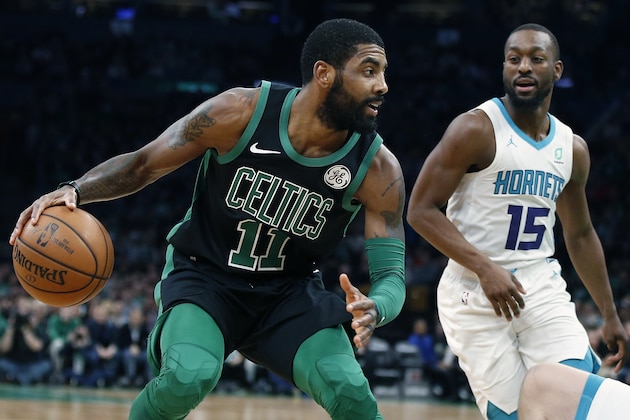 Boston Celtics' Kyrie Irving (11) drives for the basket against Charlotte Hornets' Kemba Walker (15) during the first half of an NBA basketball game in Boston, Sunday, Dec. 23, 2018. (AP Photo/Michael Dwyer)