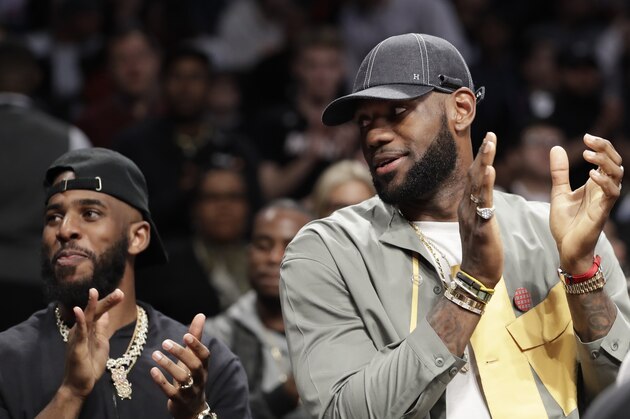 Chris Paul and LeBron James applaud during a ceremony at an NBA basketball game between the Brooklyn Nets and the Miami Heat, Wednesday, April 10, 2019, in New York. The pair were there to watch Heat guard Dwyane Wade play his last NBA game. (AP Photo/Kathy Willens)