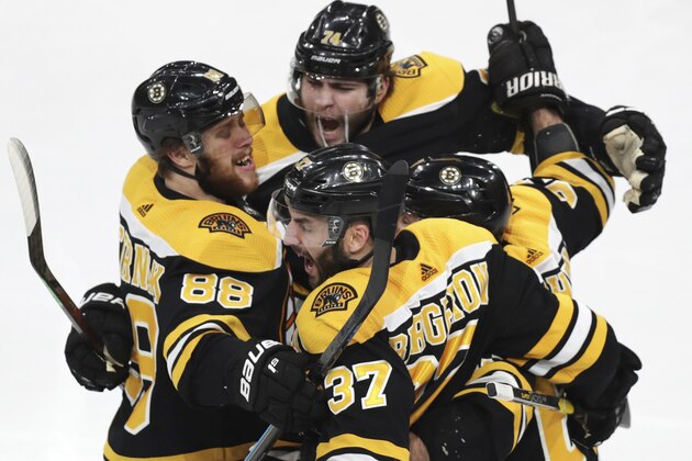 Boston Bruins' Patrice Bergeron (37) is congratulated by teammates after his goal against the Carolina Hurricanes during the third period in Game 1 of the NHL hockey Stanley Cup Eastern Conference finals, Thursday, May 9, 2019, in Boston. (AP Photo/Charles Krupa)