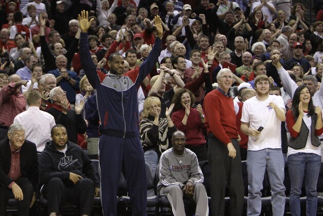 Cleveland Cavaliers' LeBron James, center, reacts after Davidson's Stephen Curry made a basket during the second half of Davidson's 72-67 win over North Carolina State in an NCAA college men's basketball game in Charlotte, N.C., Saturday, Dec. 6, 2008. (AP Photo/Chuck Burton)