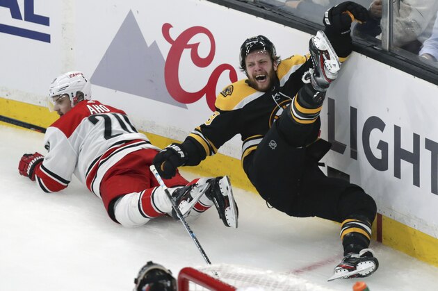 Boston Bruins' David Pastrnak, right, is upended after a check by Carolina Hurricanes' Sebastian Aho (20), of Finland, during the third period in Game 1 of the NHL hockey Stanley Cup Eastern Conference finals Thursday, May 9, 2019, in Boston. (AP Photo/Charles Krupa)