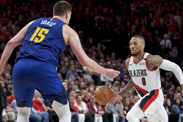 Portland Trail Blazers guard Damian Lillard, right, dribbles around Denver Nuggets center Nikola Jokic during the second half of Game 6 of an NBA basketball second-round playoff series Thursday, May 9, 2019, in Portland, Ore. The Trail Blazers won 119-108. (AP Photo/Craig Mitchelldyer)