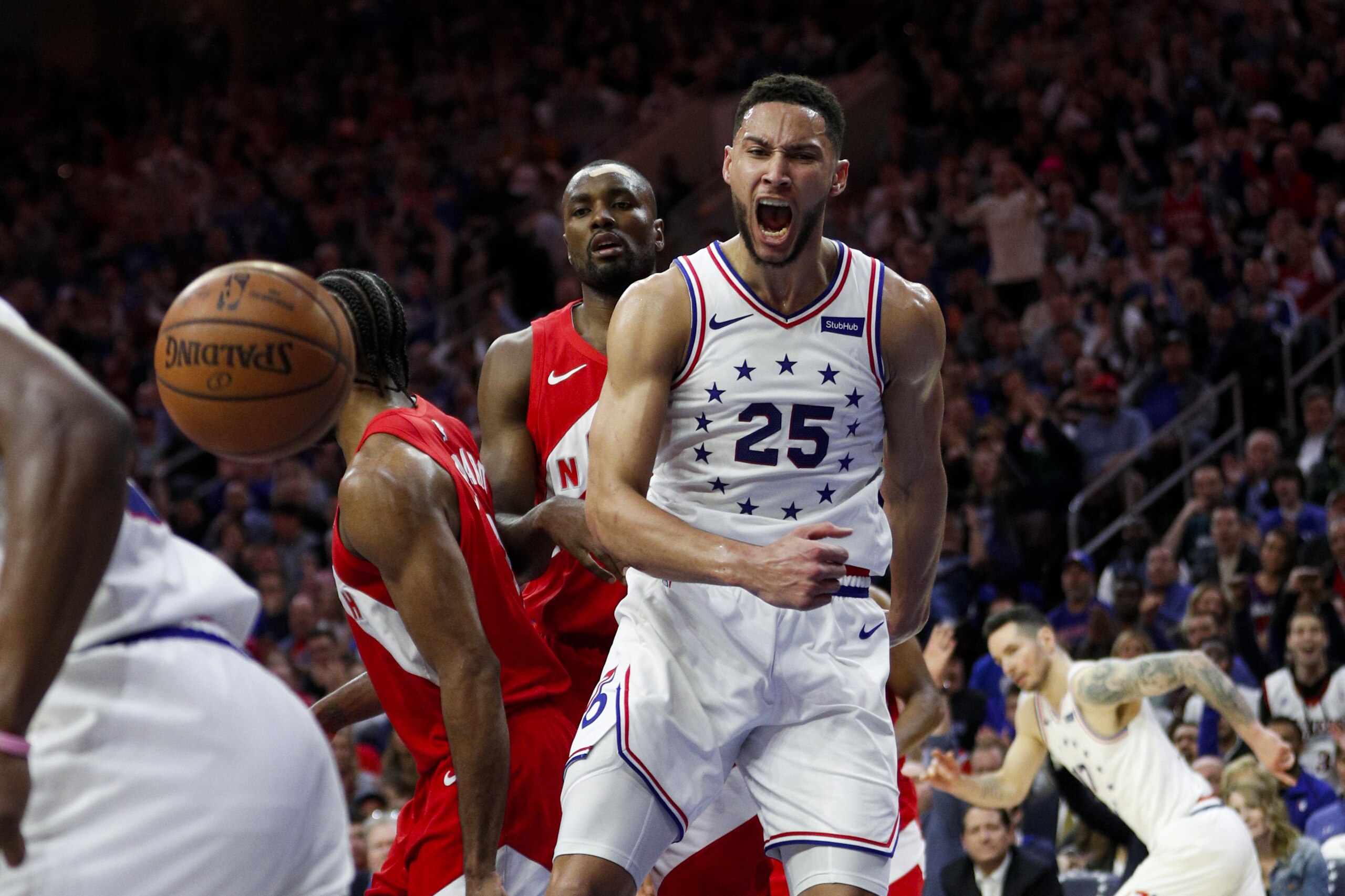 Philadelphia 76ers' Ben Simmons, right, reacts after a dunk as Toronto Raptors' Serge Ibaka watches during the first half of Game 6 of a second-round NBA basketball playoff series Thursday, May 9, 2019, in Philadelphia. (AP Photo/Chris Szagola)