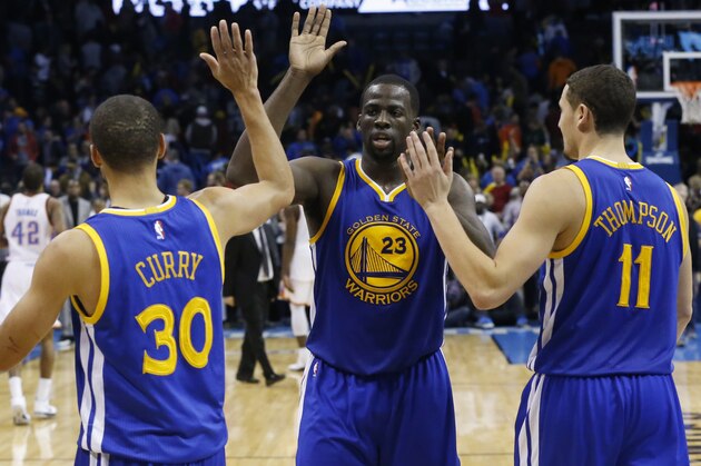 Golden State Warriors' Stephen Curry (30), Draymond Green (23) and Klay Thompson (11) celebrate after defeating the Oklahoma City Thunder in an NBA basketball game in Oklahoma City, Sunday, Nov. 23, 2014. Golden State won 91-86. (AP Photo/Sue Ogrocki)