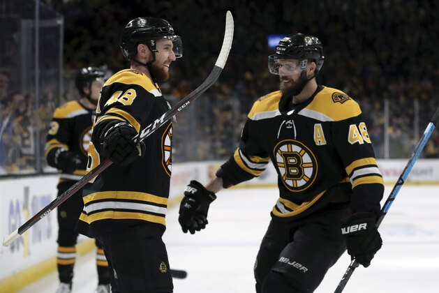 Boston Bruins' Matt Grzelcyk, left, celebrates his goal against the Carolina Hurricanes with David Krejci during the second period in Game 2 of the NHL hockey Stanley Cup Eastern Conference final series, Sunday, May 12, 2019, in Boston. (AP Photo/Charles Krupa)