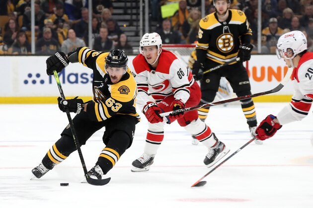BOSTON, MASSACHUSETTS - MAY 12: Brad Marchand #63 of the Boston Bruins handles the puck against Sebastian Aho #20 of the Carolina Hurricanes during the first period in Game Two of the Eastern Conference Final during the 2019 NHL Stanley Cup Playoffs at TD Garden on May 12, 2019 in Boston, Massachusetts. (Photo by Bruce Bennett/Getty Images)