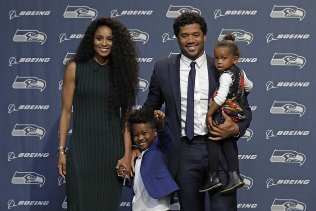 Seattle Seahawks NFL football quarterback Russell Wilson poses for photos with his wife Ciara, their daughter Sienna, and Ciara's son Future, Wednesday, April 17, 2019, in Renton, Wash., following a press conference. Earlier in the week, Wilson signed a $140 million, four-year extension with the team. (AP Photo/Ted S. Warren)