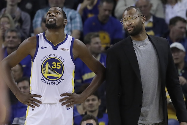 Golden State Warriors forward Kevin Durant (35) stands on the sideline with DeMarcus Cousins during the second half of an NBA basketball game against the Phoenix Suns in Oakland, Calif., Monday, Oct. 22, 2018. (AP Photo/Jeff Chiu)