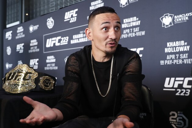 UFC featherweight champion Max Holloway gestures while responding to reporters' questions during Media Day for UFC223, Thursday, April 5, 2018, at the Barclays Center in New York ahead of his upcoming lightweight title fight against Khabib Nurmagomedov. (AP Photo/Kathy Willens)
