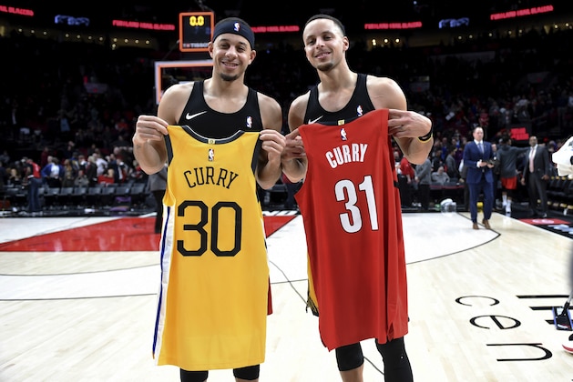 FILE - In this Dec. 29, 2018, file photo, Portland Trail Blazers guard Seth Curry, left, and his brother, Golden State Warriors guard Stephen Curry, exchange jerseys after an NBA basketball game in Portland, Ore. The Curry brothers are returning to their hometown of Charlotte, N.C, for the NBA All-Star weekend. Stephen, a two-time league MVP, will join younger brother Seth in the 3-point shootout on Saturday night at the Spectrum Center and then play in his sixth straight All-Star game on Sunday.  (AP Photo/Steve Dykes, File)