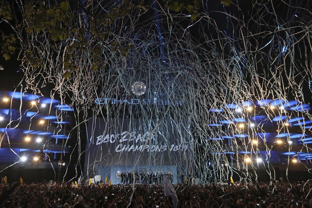 Streamers fill the night sky as the Manchester City team celebrate with their supporters at the Etihad Stadium in Manchester, England, Sunday May 12, 2019 the day they won the English Premier League title. Manchester City retained the Premier League trophy after coming from behind to beat Brighton 4-1 and see off Liverpool's relentless challenge on the final day of the season on Sunday. (AP Photo/Jon Super)