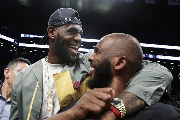 LeBron James embraces Chris Paul following an NBA basketball game between the Brooklyn Nets and the Miami Heat, Wednesday, April 10, 2019, in New York. The pair, along with Carmelo Anthony, were in New York to watch Dwyane Wade's final NBA game. (AP Photo/Kathy Willens)