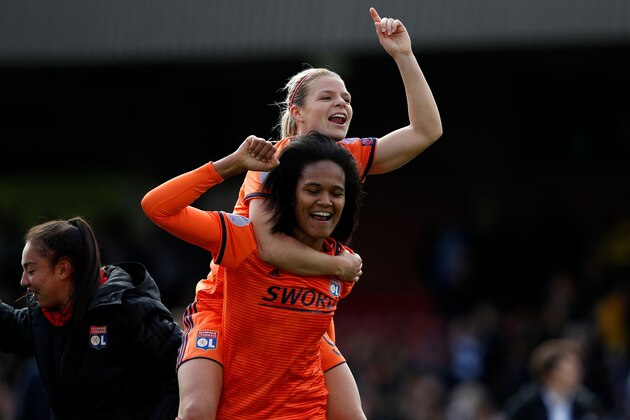 Lyon's French striker Eugenie Le Sommer (top) and Lyon's French defender Wendie Renard celebrate on the pitch after the UEFA Women's Champions League semi-final 2nd leg, football match between Chelsea and Lyon on April 28, 2019 at Cherry Red Records Stadium in Kingston-upon-Thames in south-west London. - The game finaihed 1-1, Lyon winning 3-2 on aggregate. (Photo by Adrian DENNIS / AFP)        (Photo credit should read ADRIAN DENNIS/AFP/Getty Images)
