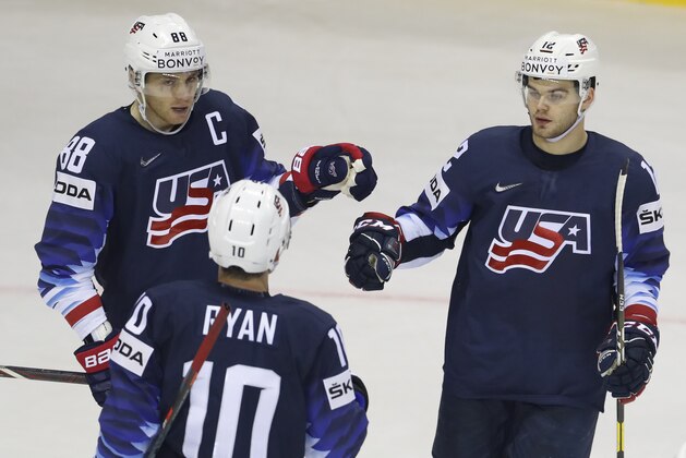 Alex Debrincat of the US, right, celebrates with teammates Patrick Kane, left, and Derek Ryan, center, after scoring his sides fourth goal during the Ice Hockey World Championships group A match between the United States and Great Britain at the Steel Arena in Kosice, Slovakia, Wednesday, May 15, 2019. (AP Photo/Petr David Josek)