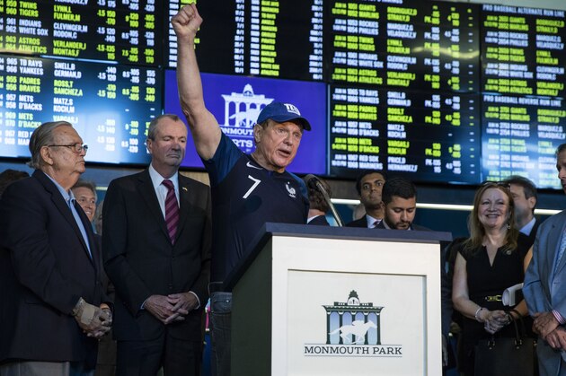 Former New Jersey State Senator Raymond Lesniak, the legal champion in the Supreme Court decision, raises his hand while speaking on June 14, 2018 before Governor Phil Murphy to placed the first bet at the Monmouth Park Sports Book on the first day of legal sports betting in the state, in in Monmouth Park in Oceanport, New Jersey. - New Jersey Gov. Phil Murphy on June 11, 2018 signed a law that authorized legal sports betting in New Jersey, ending a nearly decade-long saga that included a multimillion court battle against the nation's top sports leagues and a landmark ruling from the nation's highest court. (Photo by DOMINICK REUTER / AFP)        (Photo credit should read DOMINICK REUTER/AFP/Getty Images)