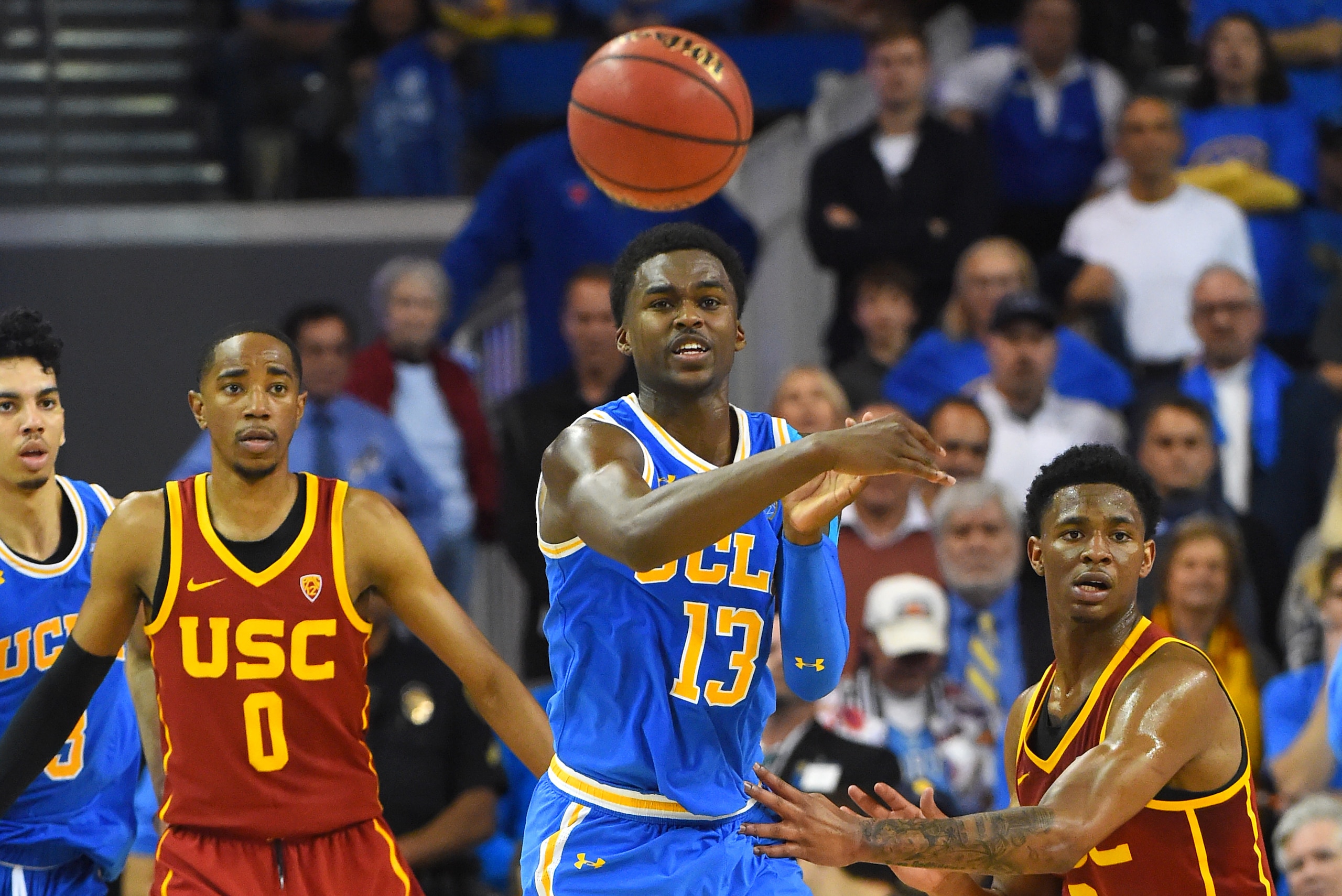 LOS ANGELES, CA - FEBRUARY 28: Kris Wilkes #13 passes the ball out to Jaylen Hands #4 of the UCLA Bruins as Shaqquan Aaron #0 and Elijah Weaver #3 of the USC Trojans defend in the overtime period of the game at Pauley Pavilion on February 28, 2019 in Los Angeles, California. (Photo by Jayne Kamin-Oncea/Getty Images)