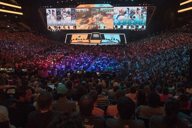 FILE - In this July 28, 2018, file photo, fans watch the competition between Philadelphia Fusion and London Spitfire during the Overwatch League Grand Finals competition at Barclays Center in the Brooklyn borough of New York. With eight new franchises and plans to take its regular season on the road for the first time, the Overwatch League is opening its second year a few steps closer to its goal of becoming a truly global, city-based esports league. (AP Photo/Mary Altaffer, File)