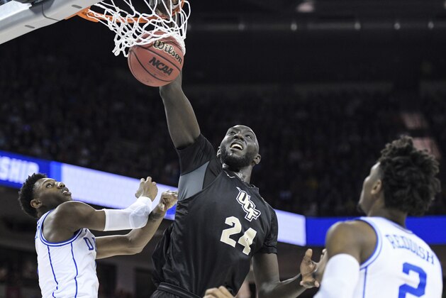 Central Florida center Tacko Fall (24) dunks the ball against Duke forward RJ Barrett, left, as Cam Reddish (2) looks on, during the second half of a second-round game in the NCAA men's college basketball tournament Sunday, March 24, 2019, in Columbia, S.C. Duke defeated Central Florida 77-76. (AP Photo/Sean Rayford)