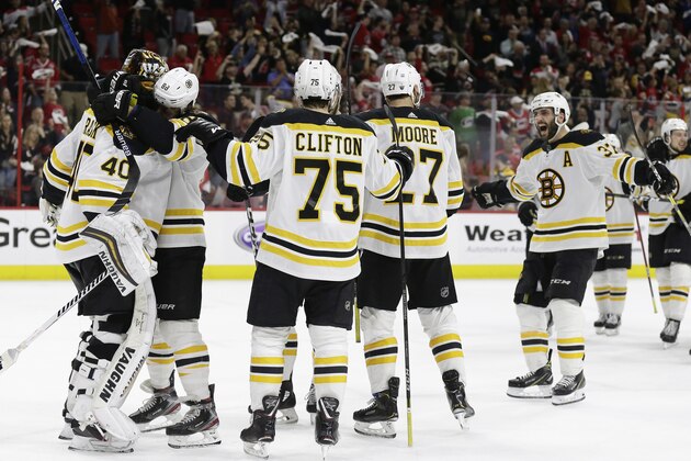 Boston Bruins goalie Tuukka Rask, left, of Finland, is congratulated by teammates following Game 4 of the NHL hockey Stanley Cup Eastern Conference finals against the Carolina Hurricanes in Raleigh, N.C., Thursday, May 16, 2019. Boston won 4-0 to advance to the Stanley Cup Final. (AP Photo/Gerry Broome)