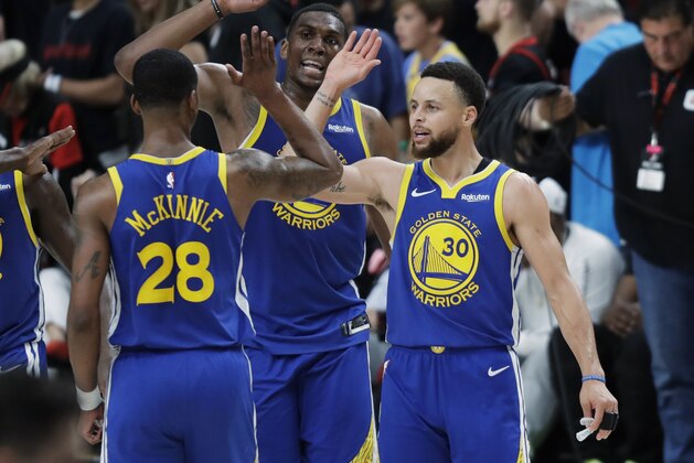 Golden State Warriors guard Stephen Curry, right, greets Alfonzo McKinnie (28) and Kevon Looney, center, during the second half of Game 3 of the team's NBA basketball playoffs Western Conference finals against the Portland Trail Blazers, Saturday, May 18, 2019, in Portland, Ore. The Warriors won 110-99. (AP Photo/Ted S. Warren)