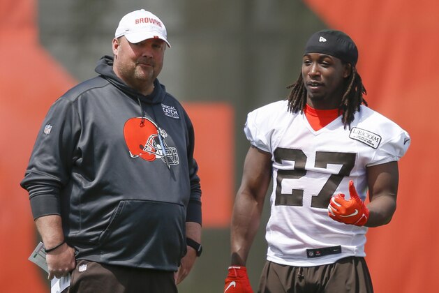 FILE - In this May 15, 2019, file photo, Cleveland Browns' Kareem Hunt (27) talks with head coach Freddie Kitchens during an NFL football organized team activity session at the team's training facility in Berea, Ohio. Kitchens has been watching Kareem Hunt work toward redemption. On Sunday, May 19, Kitchens showed the running back that he’s got his full support. Kitchens and general manager John Dorsey surprised Hunt by attending his baptism at True Vine Missionary Baptist Church on Cleveland’s east side. Hunt, who has been suspended eight games by the NFL for two physical altercations, including one in which he shoved and kicked a woman, said last week he wanted “to feel reborn.”(AP Photo/Ron Schwane, File)