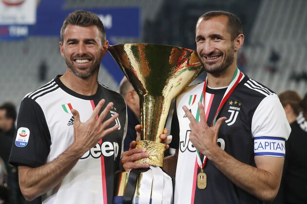 Juventus' Andrea Barzagli, left, and Juventus' Giorgio Chiellini pose with the Serie A soccer title trophy, at the Allianz Stadium, in Turin, Italy, Wednesday, April 3, 2019. (AP Photo/Antonio Calanni)