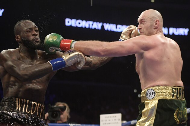 File-This Dec. 1, 2018, file photo shows Deontay Wilder, left, and Tyson Fury, of England, trading punches during a WBC heavyweight championship boxing match in Los Angeles. The WBC heavyweight title rematch between champion Wilder and Fury is off for now. The two fought to a draw in December and were negotiating a rematch. But WBC President Mauricio Sulaiman said Tuesday, Feb. 26, 2019, he received confirmation from Fury that the challenger would look elsewhere for his next bout. (AP Photo/Mark J. Terrill, File)