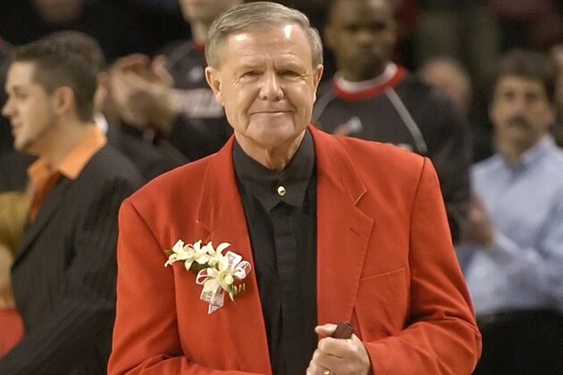 Holding his trademark rolled up program, former Louisville basketball coach Denny Crum takes the floor for a ceremony naming the court in his honor Wednesday, Feb. 7, 2007 at Freedom Hall in Louisville, Ky. (AP Photo/Timothy D. Easley)