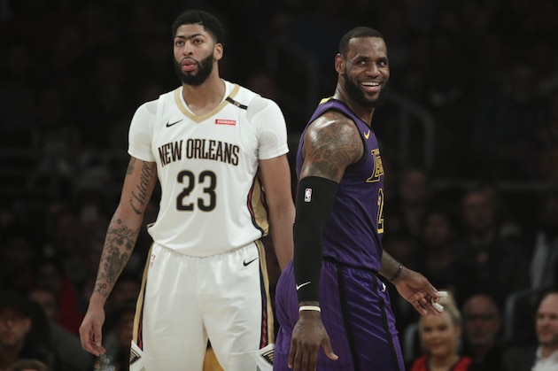 Los Angeles Lakers' LeBron James, right, smiles as he walks past New Orleans Pelicans' Anthony Davis during the first half of an NBA basketball game Friday, Dec. 21, 2018, in Los Angeles. (AP Photo/Jae C. Hong)