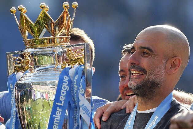 Manchester City coach Pep Guardiola lifts the English Premier League trophy after the English Premier League soccer match between Brighton and Manchester City at the AMEX Stadium in Brighton, England, Sunday, May 12, 2019. Manchester City defeated Brighton 4-1 to win the championship. (AP Photo/Frank Augstein)